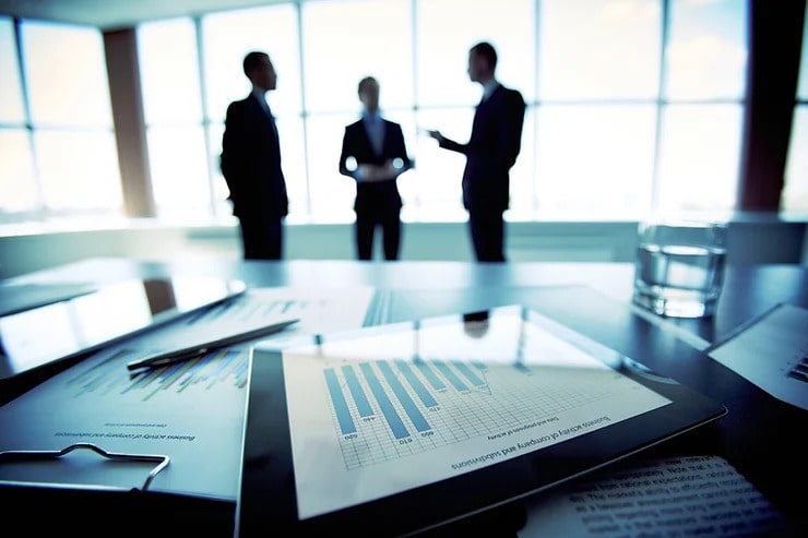 3 men in suit discussing in conference room